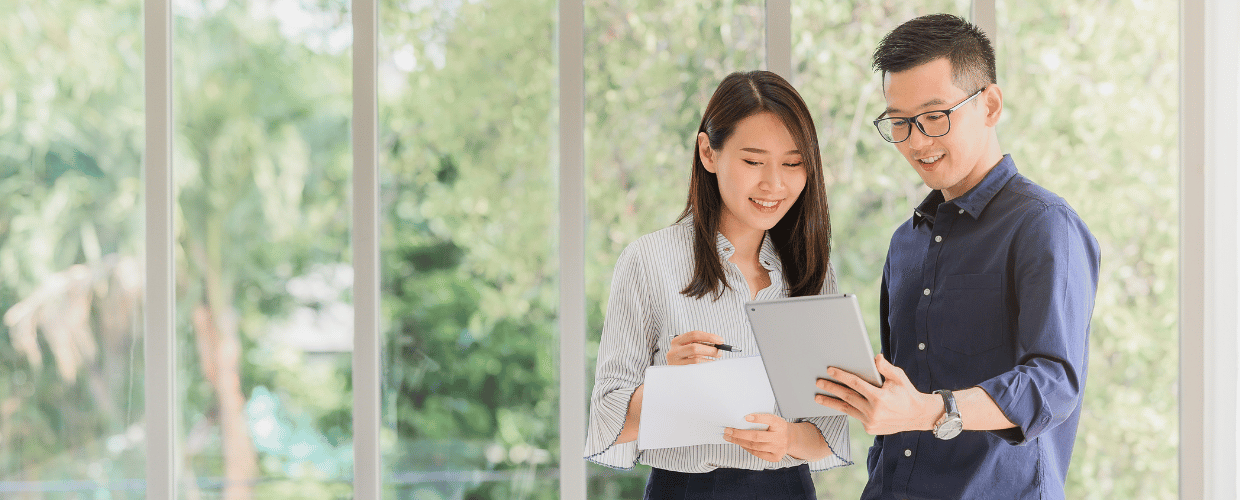 asian woman and man reading tablet