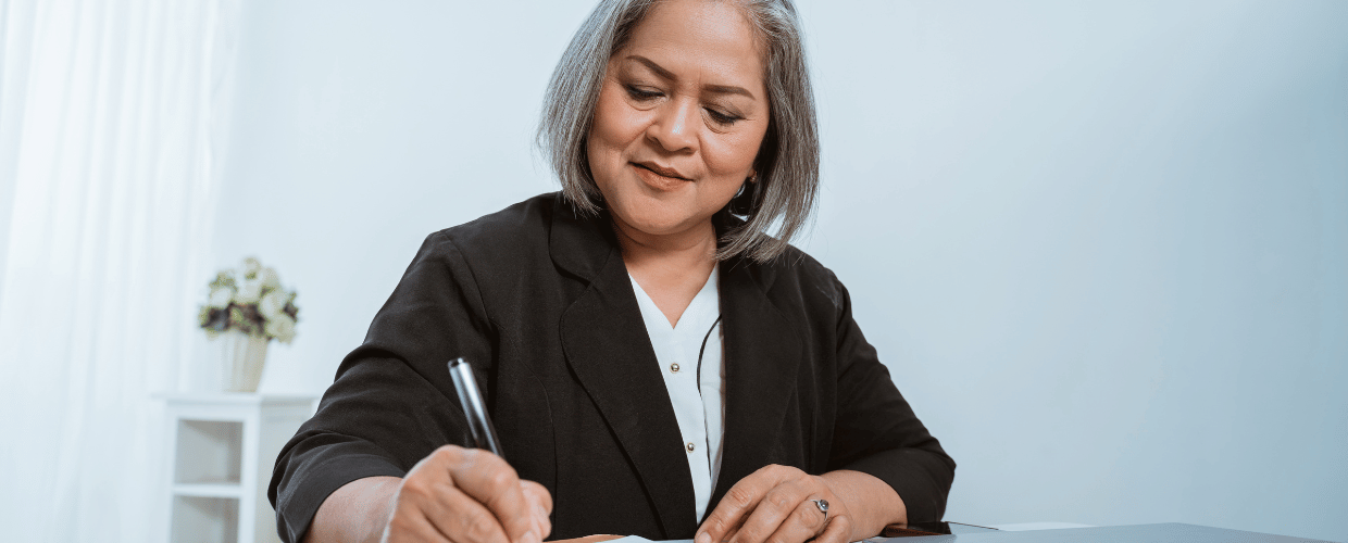 old asian business woman signing paper